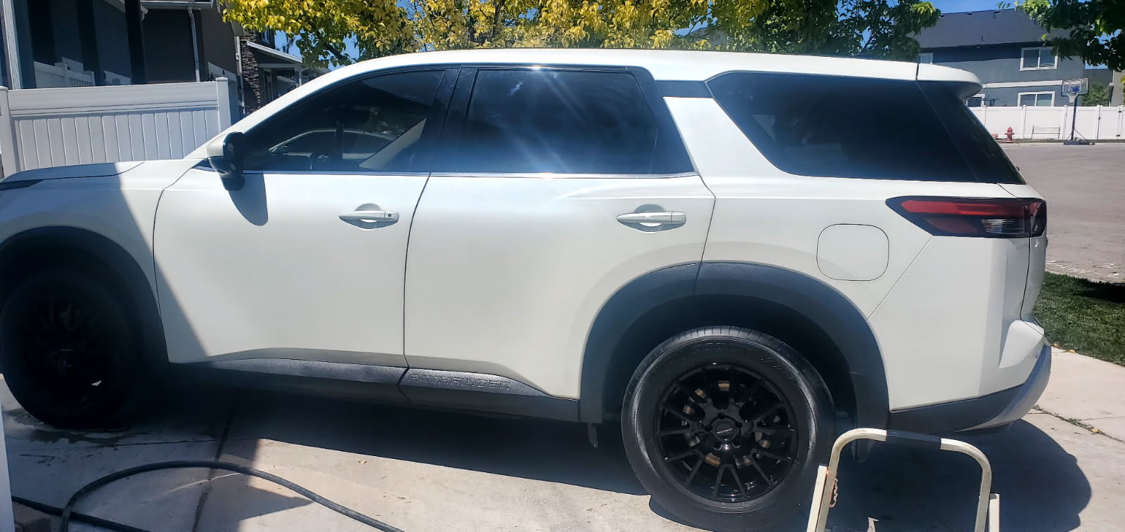 White Nissan Pathfinder SUV after wash — side profile view